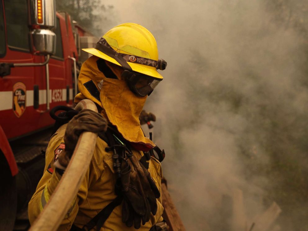 PHOTO: A Cal Fire Fresno Firefighter monitors wildfire activity in front of a home, Oct. 13, 2017, in Glen Ellen , Calif.