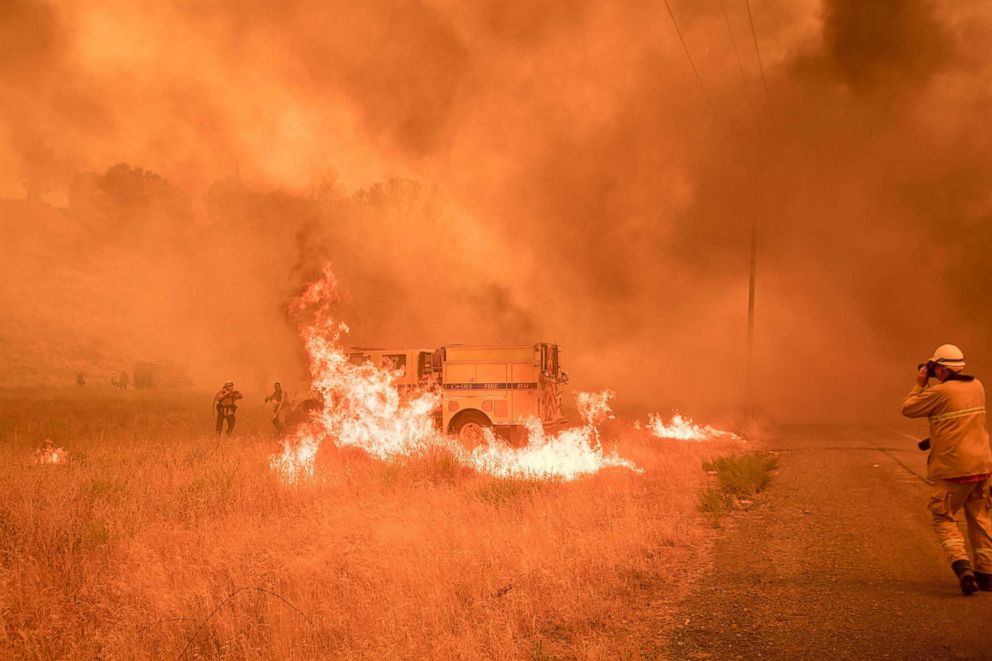 PHOTO: Firefighters scramble to control flames surrounding a fire truck as the Pawnee fire jumps across highway 20 near Clearlake Oaks, California, July 1, 2018.