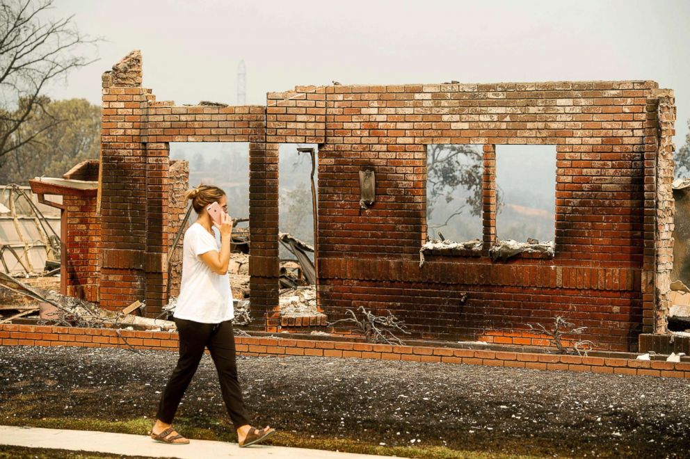 PHOTO: A woman surveys damage to her grandmother's house after the Carr Fire burned through Redding, Calif., July 27, 2018.