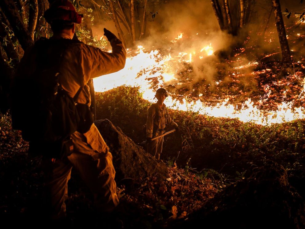 PHOTO: CALFIRE firefighter Tim Zanotelli, center, receives instructions from Captain Gary Mattingly, left, while performing a firing operation to prevent the flames from crossing Highway 29, north of Calistoga, Calif., Oct. 12, 2017.