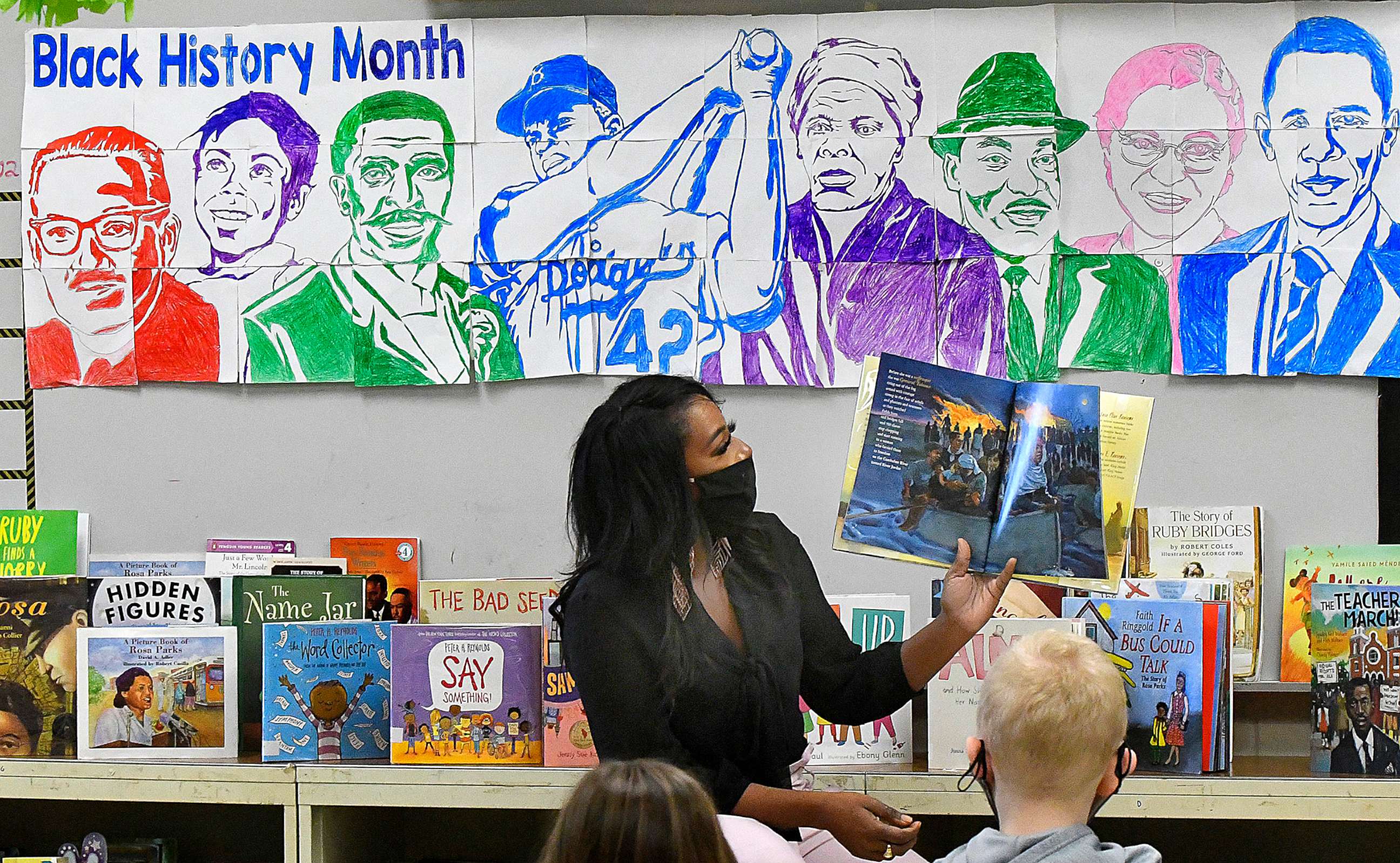 PHOTO: In this Feb. 23, 2021, file photo, Grove Elementary School teacher Cameo Williams reads a book about Harriet Tubman to her third grade schools against the backdrop of a mural they created for Black History Month, in Normal, Ill.