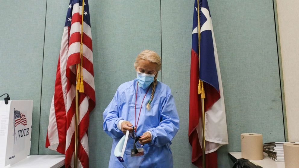 PHOTO: Cameron County early voting clerk Mary Helen Barrera puts on her personal protective equipment before heading out to the curbside voting area before the early voting polling location opens in Brownsville, Texas, on Oct. 15, 2020.
