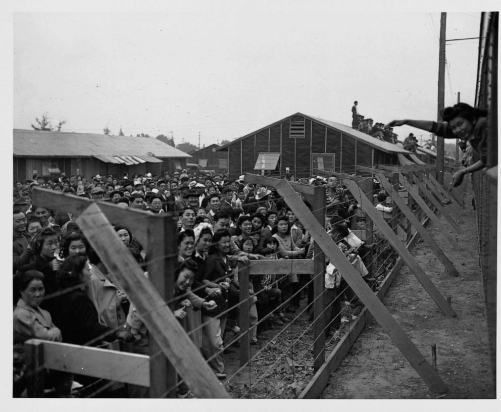 PHOTO: Japanese-American internees wave to friends departing by train from the Santa Anita Assembly Center at Santa Anita Racetrack in Arcadia, Calif., 1942. 