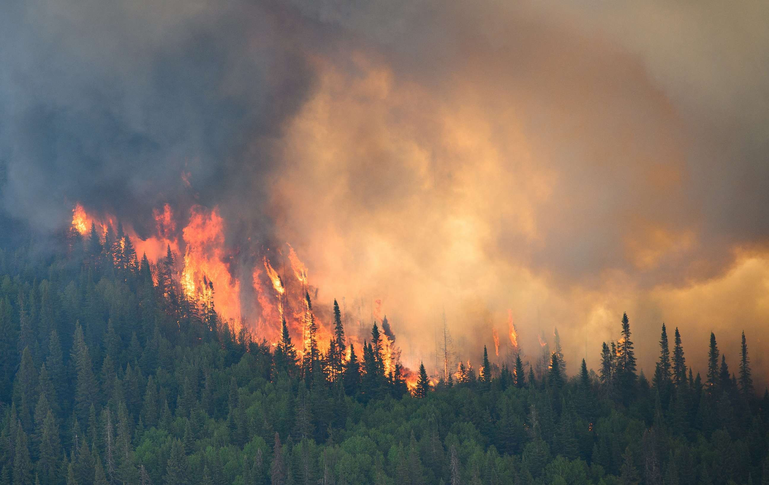 PHOTO: Flames reach upwards along the edge of a wildfire as seen from a Canadian Forces helicopter surveying the area near Mistissini, Quebec, Canada, June 12, 2023.