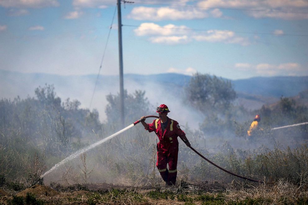 PHOTO: A firefighter directs water on a grass fire burning on an acreage behind a residential property in Kamloops, British Columbia, Canada, June 5, 2023.