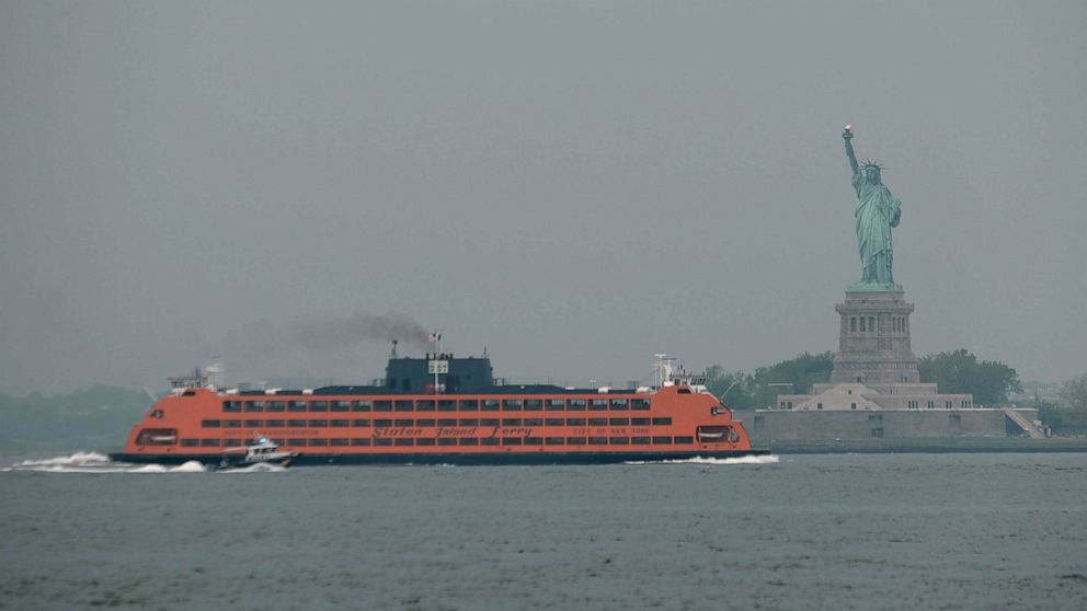 PHOTO: The Staten Island Ferry moves past the Statue of Liberty on a hazy morning resulting from Canadian wildfires, June 06, 2023 in New York City.