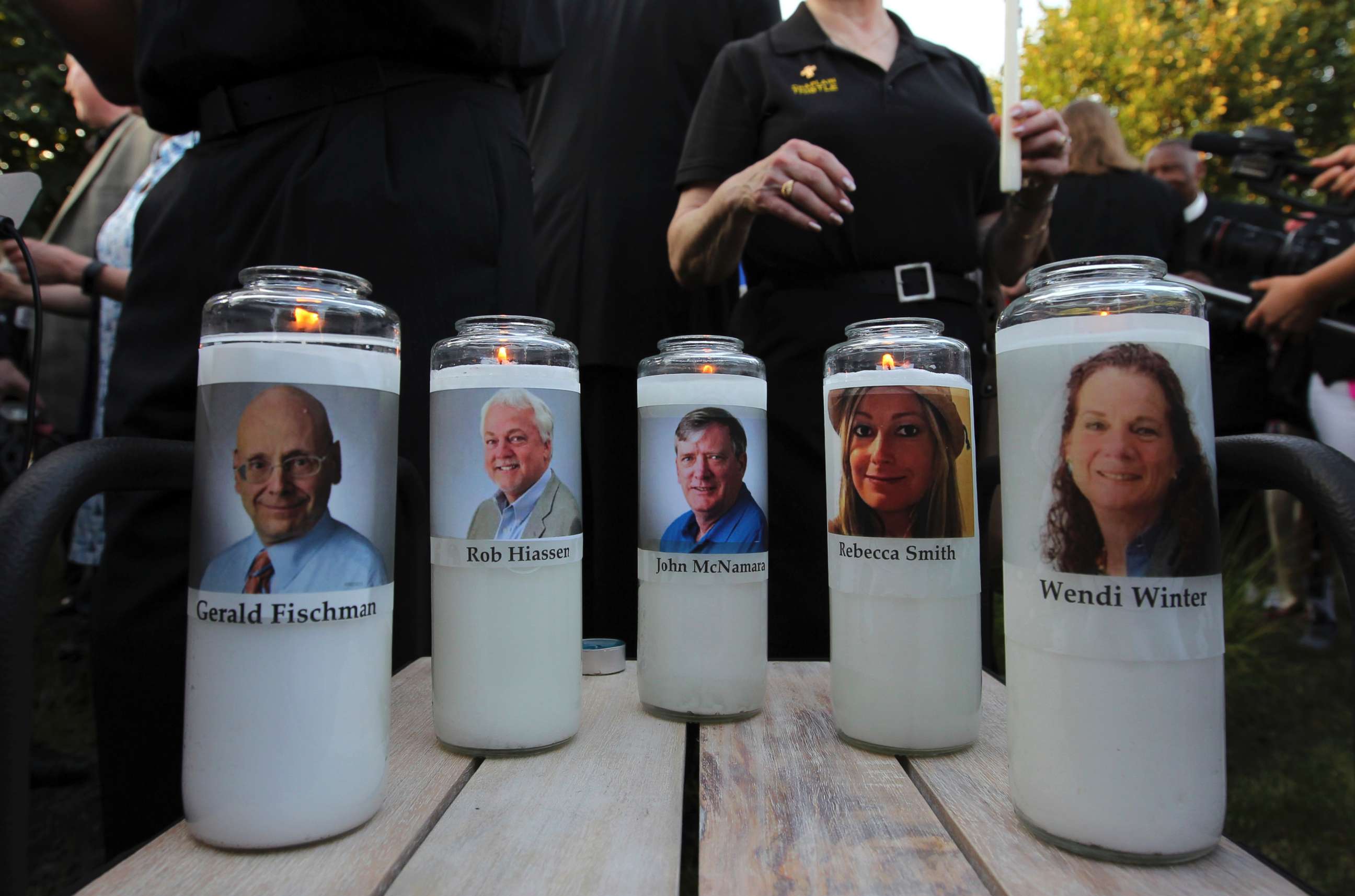 PHOTO: Photos of five journalists adorn candles during a vigil across the street from where they were slain in their newsroom in Annapolis, Md., June 29, 2018.