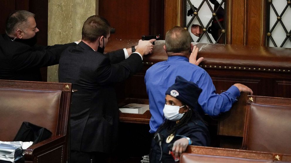 PHOTO: Police with guns drawn watch as protesters try to break into the House Chamber at the U.S. Capitol, Jan. 6, 2021, in Washington.