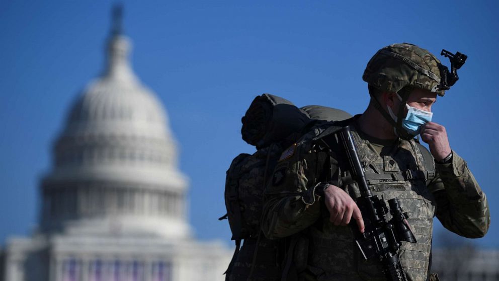 PHOTO: A member of the National Guard adjusts his protective mask near the Capitol building in Washington, Jan. 13, 2021.
