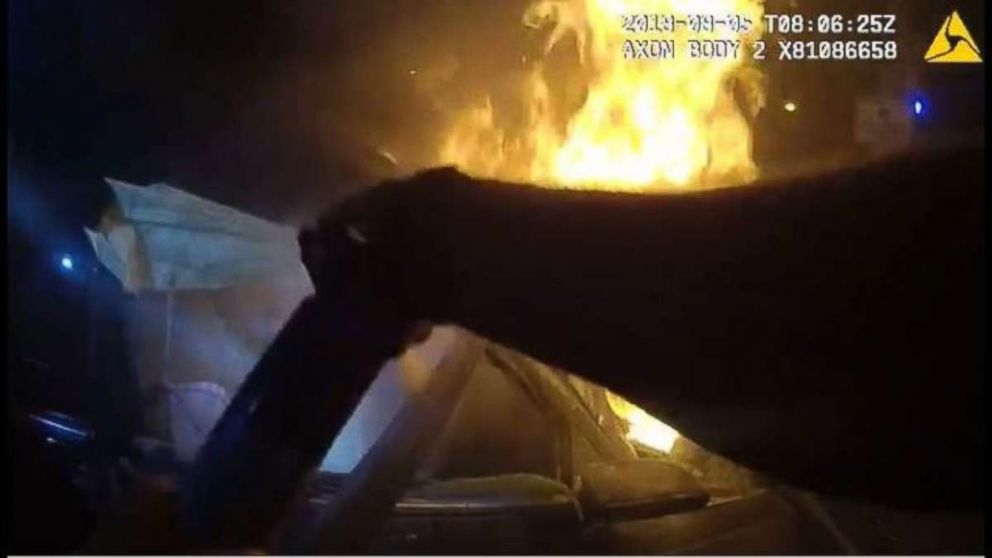 An Atlanta police officer tries to put out the burning engine with a fire extinguisher before pulling the passenger to safety.