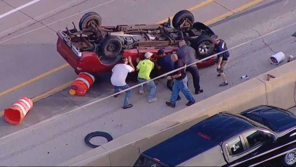 PHOTO: Good Samaritans rescue a driver after a pickup flips on the highway in Oak Brook, Ill. , July 22, 2019.