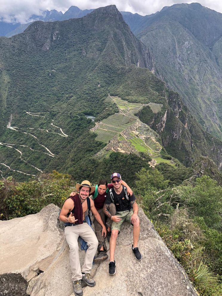 PHOTO: Carla Valpeoz, a partially blind traveler who has gone missing in Peru, poses for a photo with two men on a peak overlooking Machu Picchu in southern Peru.