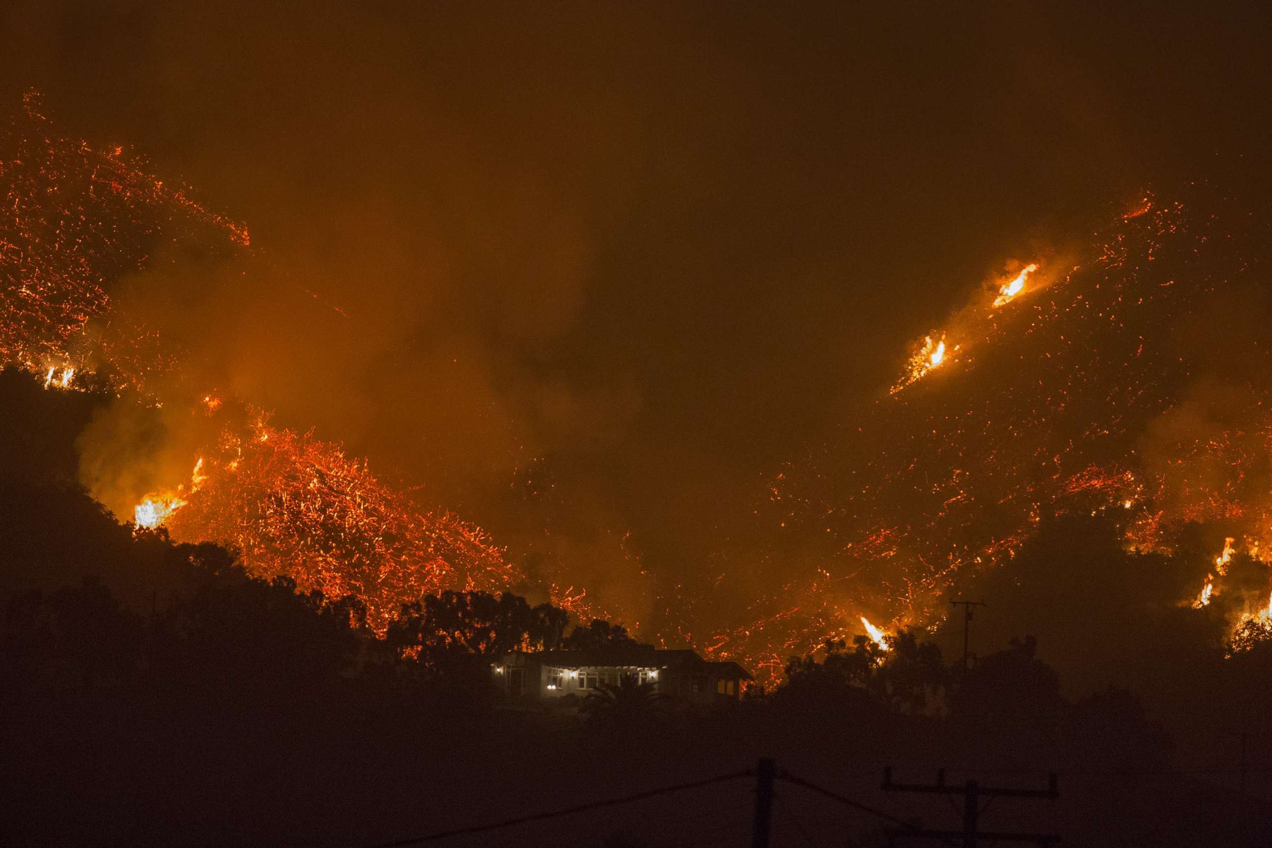 PHOTO: Flames come close to a house as the Thomas Fire advances toward Santa Barbara County seaside communities, Dec. 10, 2017, in Carpinteria, Calif.