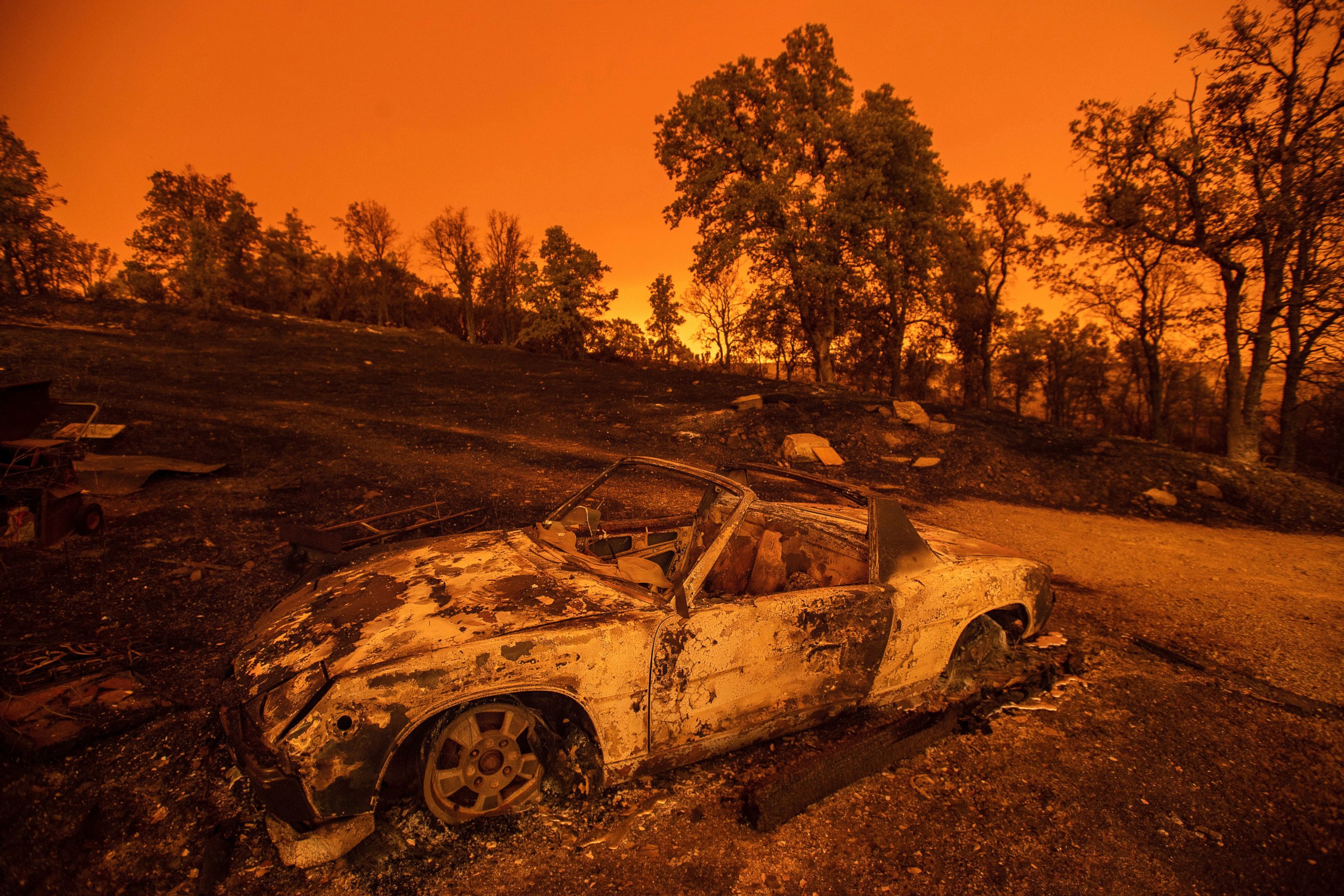 Cars scorched by the Carr Fire rest at a residence in Redding, Calif., on Friday, July 27, 2018. The fire rapidly expanded Thursday when flames swept through the Gold Rush town of Shasta, then jumped the Sacramento River into Redding.