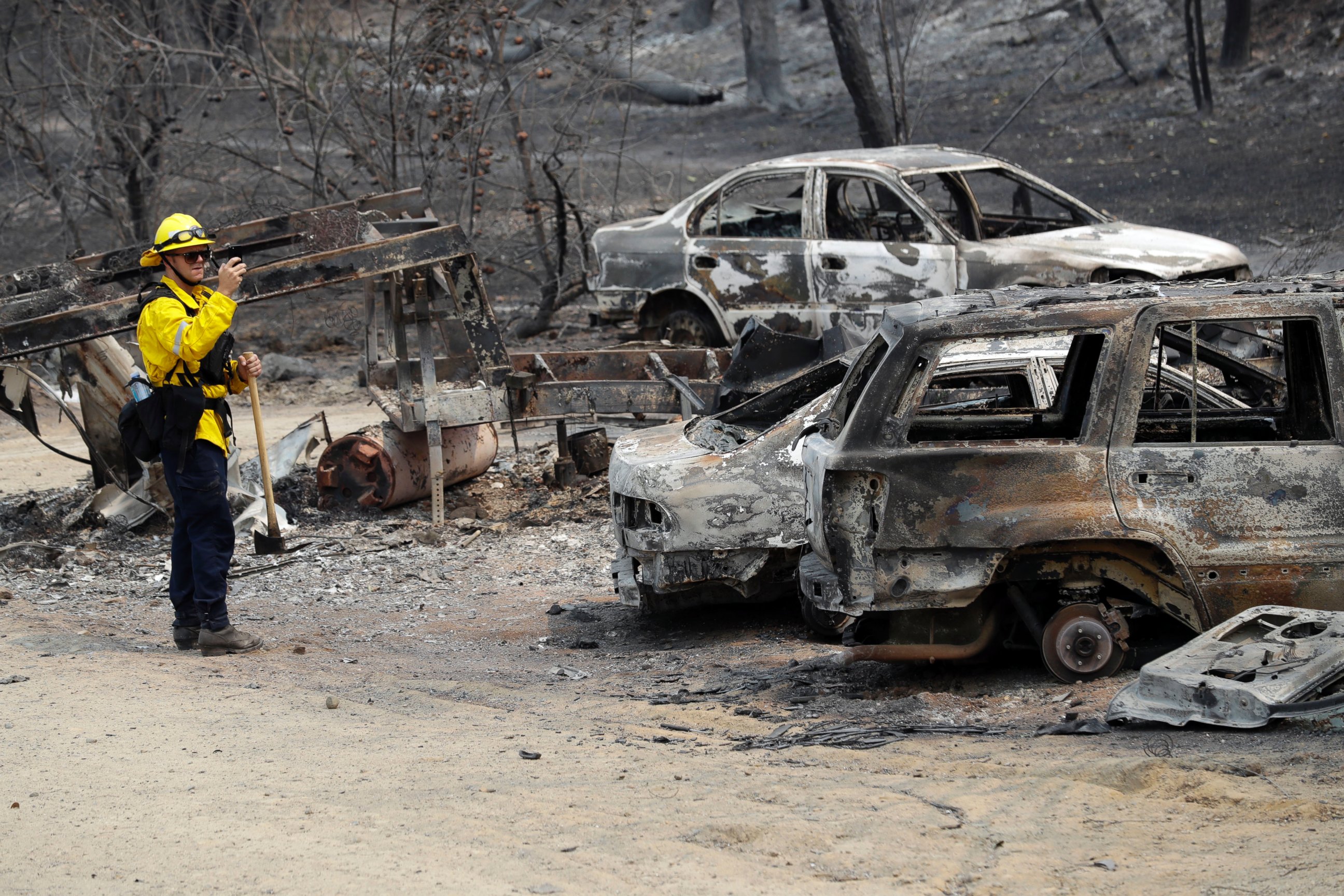 San Bernardino County Fire Department firefighter James Lippen takes photos of the damage caused by a wildfire, Sunday, July 29, 2018, in Keswick, Calif.