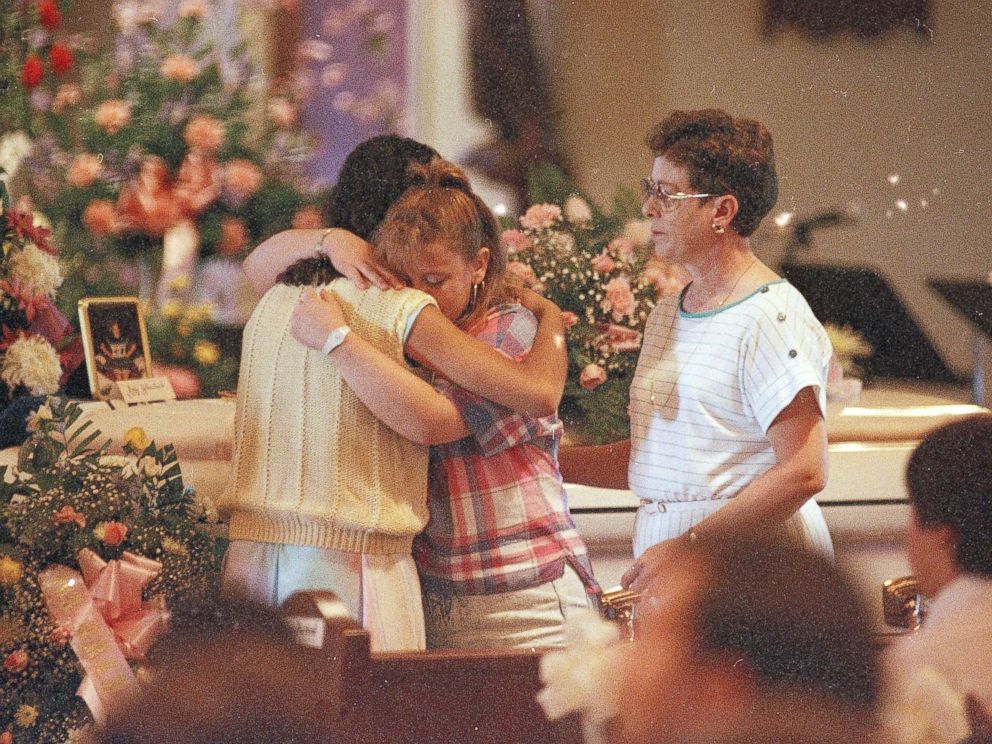 PHOTO: Two young women embrace each other as they stand in front of the casket of Amy Christine Wheelock during her funeral Mass at St. Christopher Church in Radcliff, Ky., May 18, 1988.