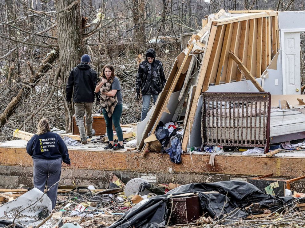 PHOTO: Chelsea Emmons holds onto a cat that belongs to her mother, Kim Goforth, Dec. 11, 2021, in Bremen, Ky., while searching Goforth's following a tornado that struck overnight. 