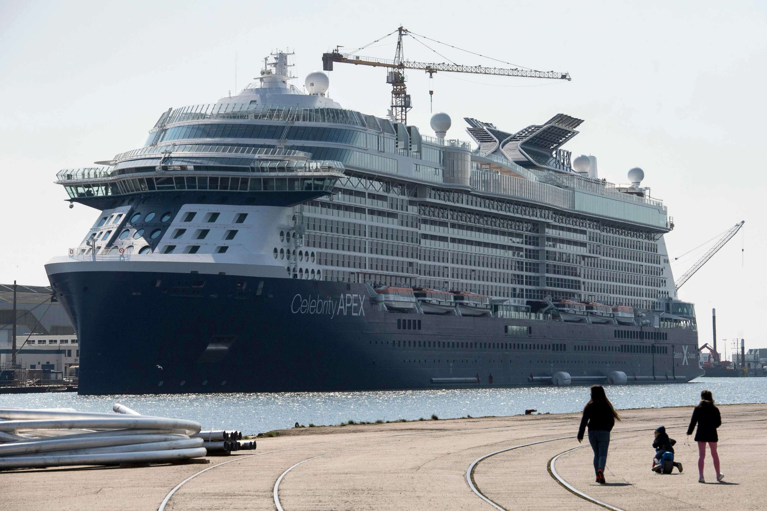 PHOTO: Children walk past the new Celebrity cruises ship "Celebrity Apex" at Les Chantiers de l'Atlantique shipyards, in Saint-Nazaire, France, April 2, 2020, on the seventeenth day of a strict lockdown in France to stop the spread of COVID-19.