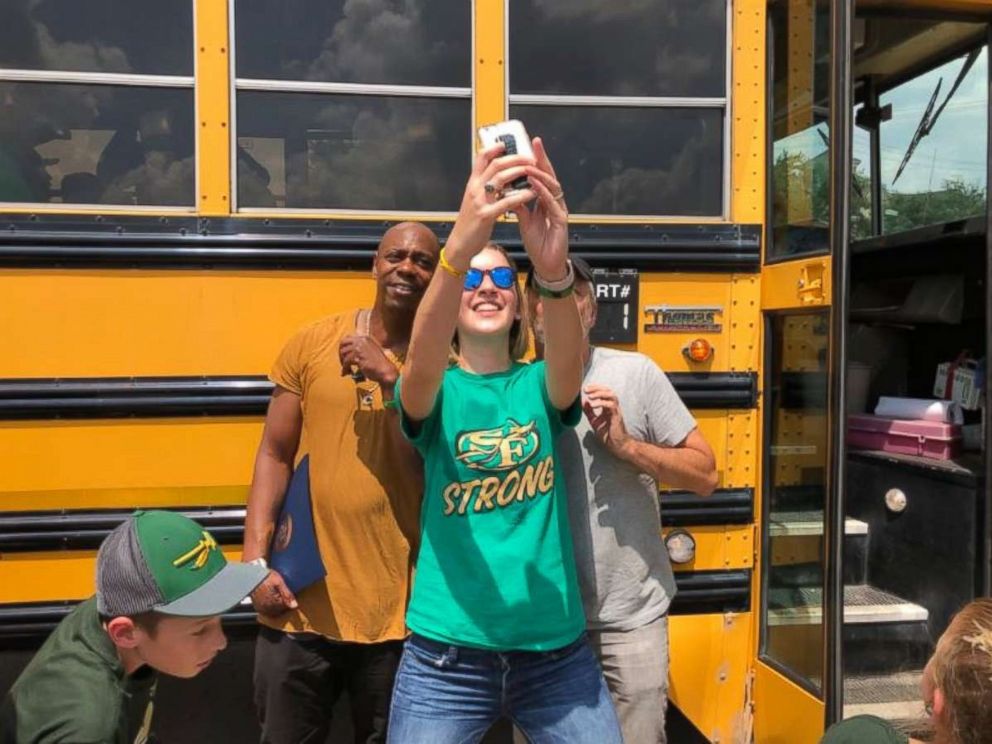 Dave Chappelle and Jon Stewart pose for a selfie with a woman wearing a "Santa Fe Strong" T-shirt on Friday, June 22, 2018.