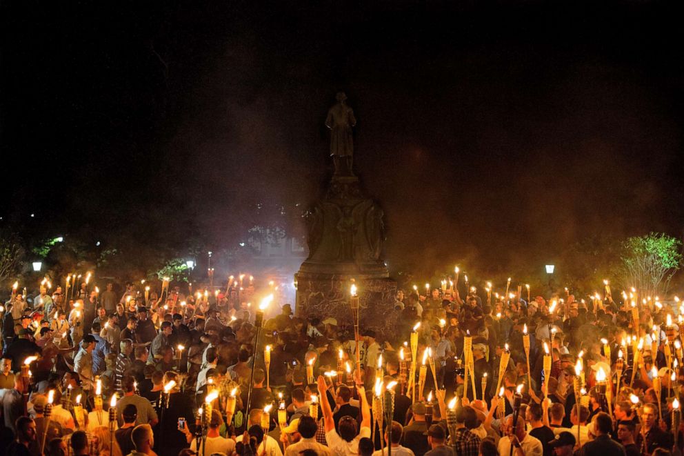 PHOTO: Demonstrators carrying torches encircle counter protestors at the base of the statue of Thomas Jefferson after marching through the University of Virginia campus with in Charlottesville, Va., Aug. 11, 2017.