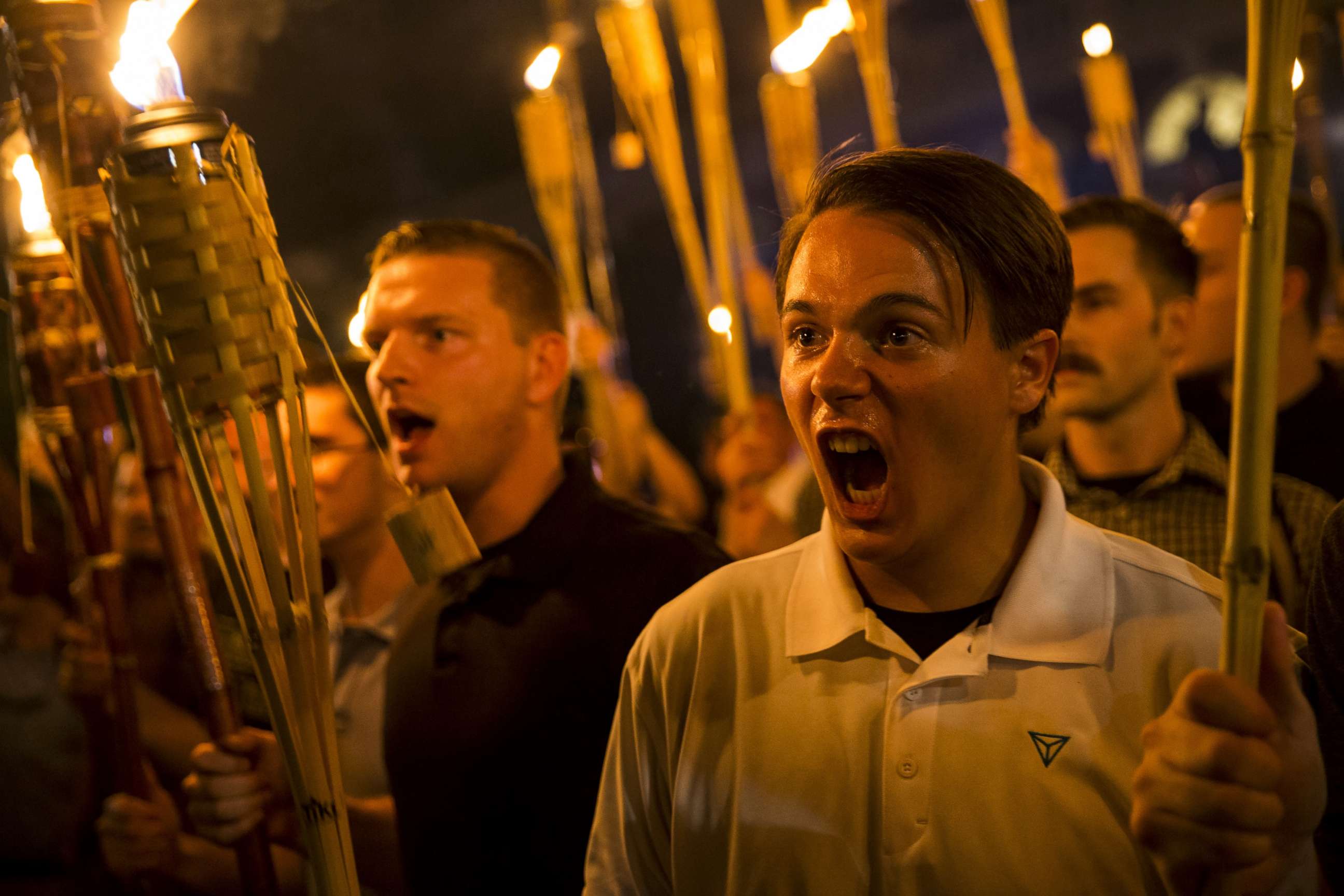 PHOTO: Peter Cvjetanovic, right,along with Neo Nazis, Alt-Right, and White Supremacists encircle and chant at counter protesters after marching through the University of Virginia campus with torches in Charlottesville, Va., on Aug. 11, 2017. 