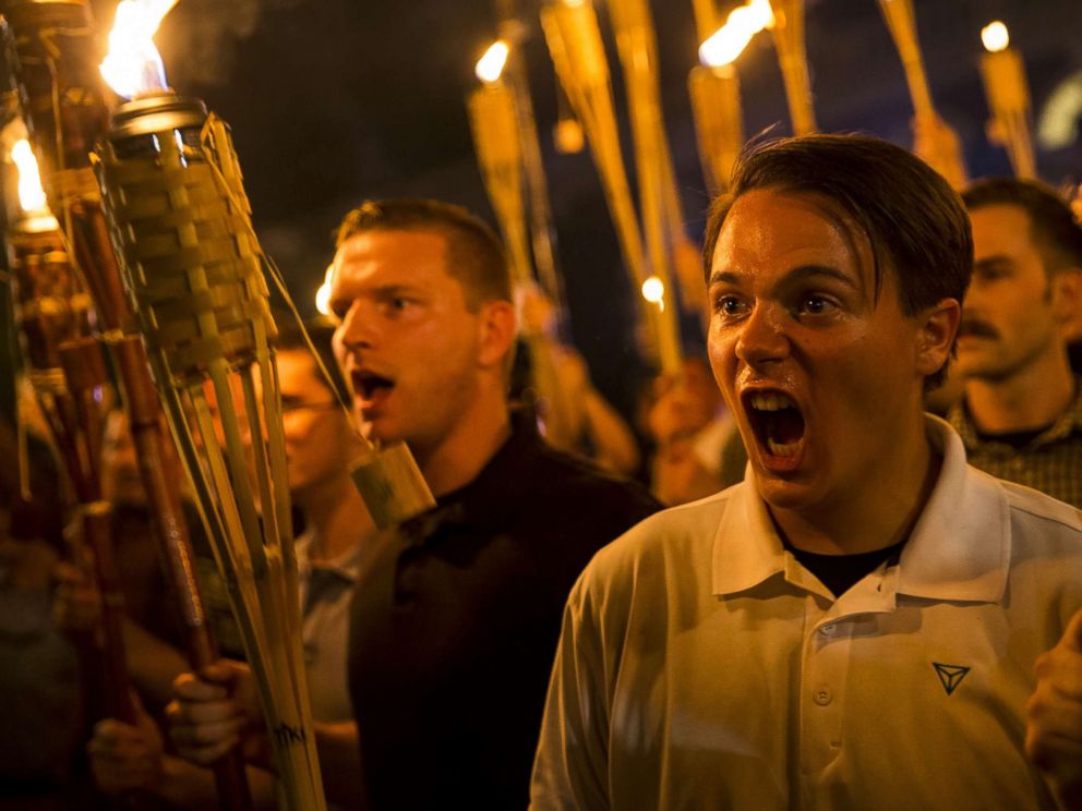 PHOTO: Peter Cvjetanovic, right,along with Neo Nazis, Alt-Right, and White Supremacists encircle and chant at counter protesters after marching through the University of Virginia campus with torches in Charlottesville, Va., on Aug. 11, 2017.