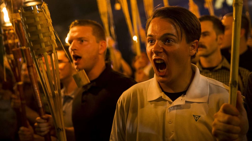 Peter Cvjetanovic, right, along with Neo Nazis, Alt-Right, and White Supremacists encircle and chant at counter-protesters after marching through the University of Virginia campus with torches in Charlottesville, Va., Aug. 11, 2017.