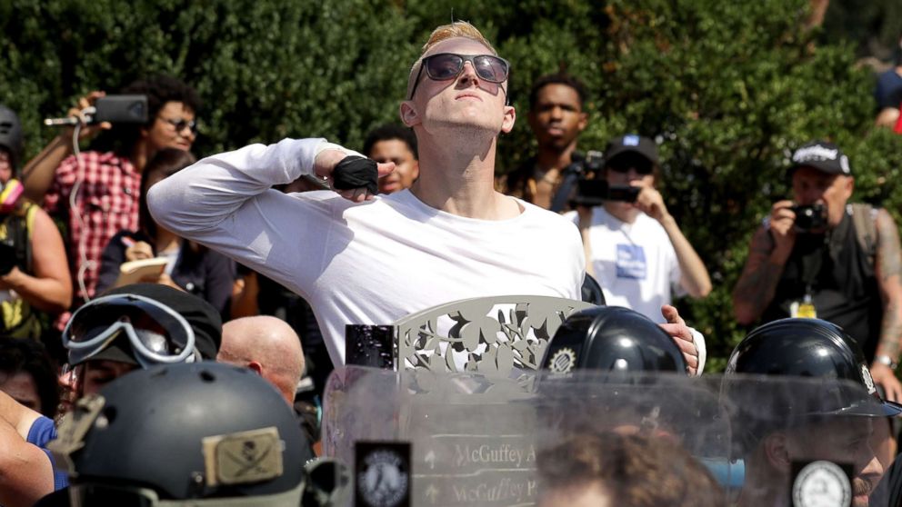 PHOTO: A man makes a slashing motion across his throat toward counter-protesters as he marches with white nationalists, neo-Nazis and members of the "alt-right" during the "Unite the Right" rally, Aug. 12, 2017, in Charlottesville, Va.