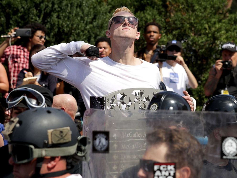 PHOTO: A man makes a slashing motion across his throat toward counter-protesters as he marches with white nationalists, neo-Nazis and members of the alt-right during the Unite the Right rally, Aug. 12, 2017, in Charlottesville, Va.