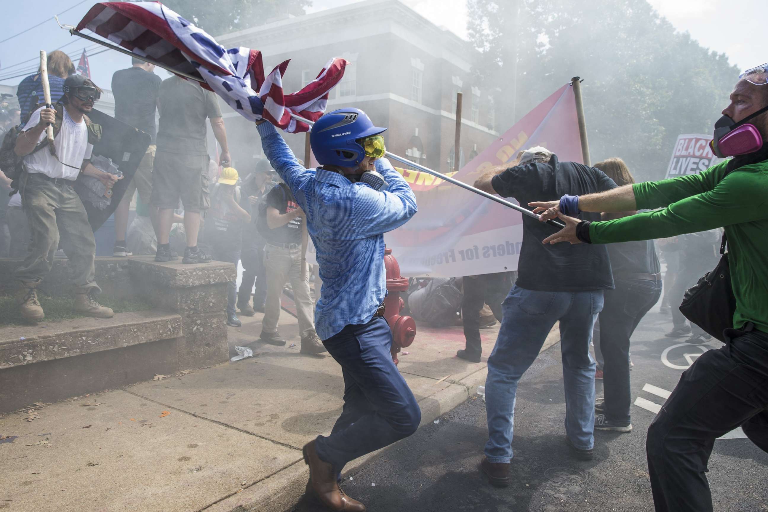 PHOTO: A white supremacist tries to strike a counter-protester with a flag during clashes at Emancipation Park where the White Nationalists are protesting the removal of the Robert E. Lee monument in Charlottesville, Va., Aug. 12, 2017.