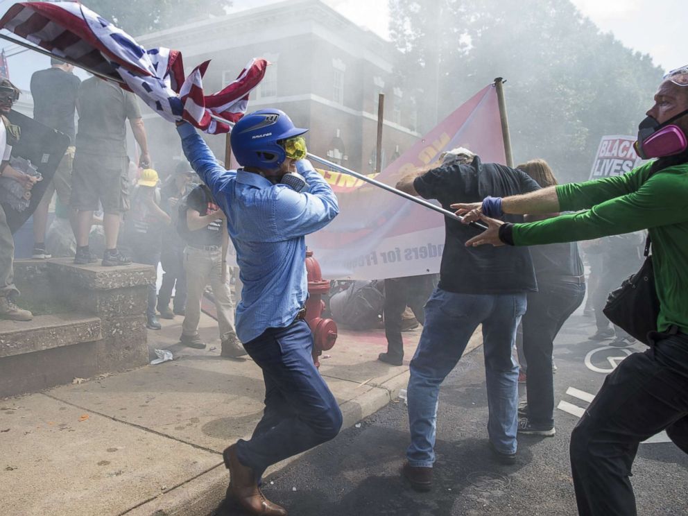 PHOTO: A white supremacist tries to strike a counter-protester with a flag during clashes at Emancipation Park where the White Nationalists are protesting the removal of the Robert E. Lee monument in Charlottesville, Va., Aug. 12, 2017.