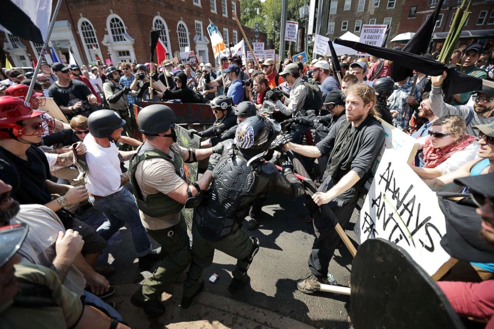 PHOTO: White nationalists, neo-Nazis and members of the extreme right clash with counter-protesters as they enter Lee Park during a rally on Aug. 12, 2017 in Charlottesville, Va. 