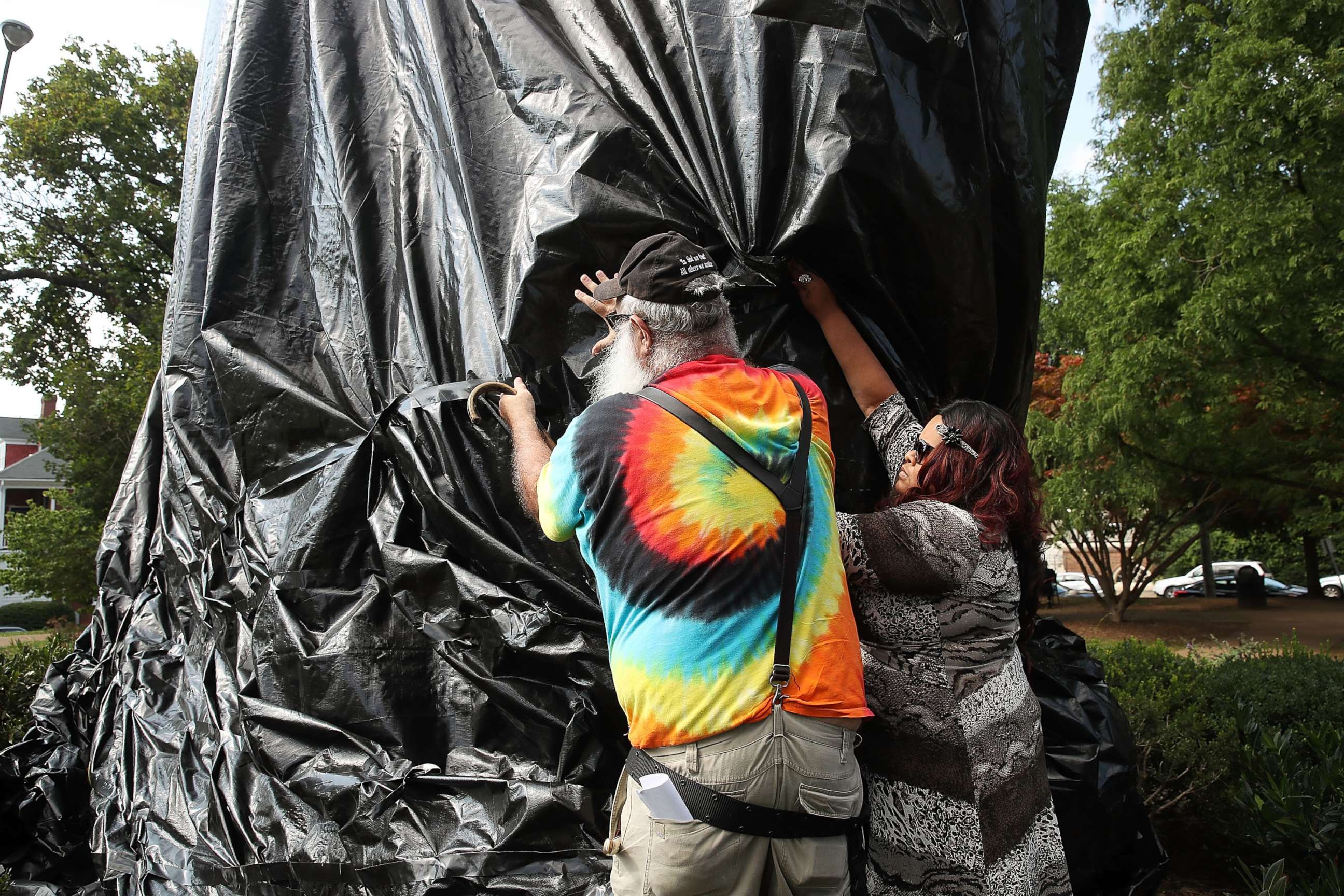 PHOTO: A women tries to stop John Miska from cutting off the black tarp that was put over the statue of Confederate Gen. Robert E. Lee that stands in the center of Emancipation Park, formerly Lee Park, on Aug. 23, 2017 in Charlottesville, Va.