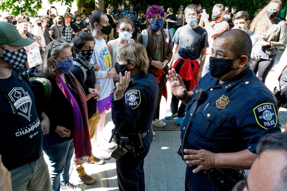 PHOTO: Seattle Police Assistant Chief Deanna Nollette and Assistant Chief Adrian Diaz are blocked by protesters from entering the newly created Capitol Hill Autonomous Zone (CHAZ) in Seattle, June 11, 2020.