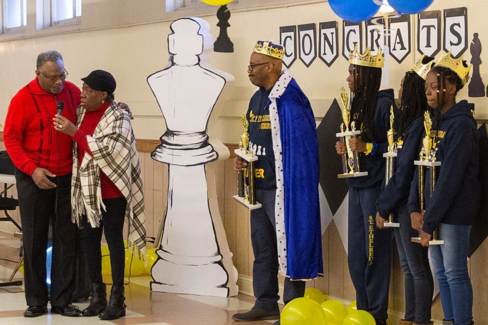 PHOTO: Coach Luster and the three winners of the Illinois Chess Championship are celebrated at the school's pep rally.