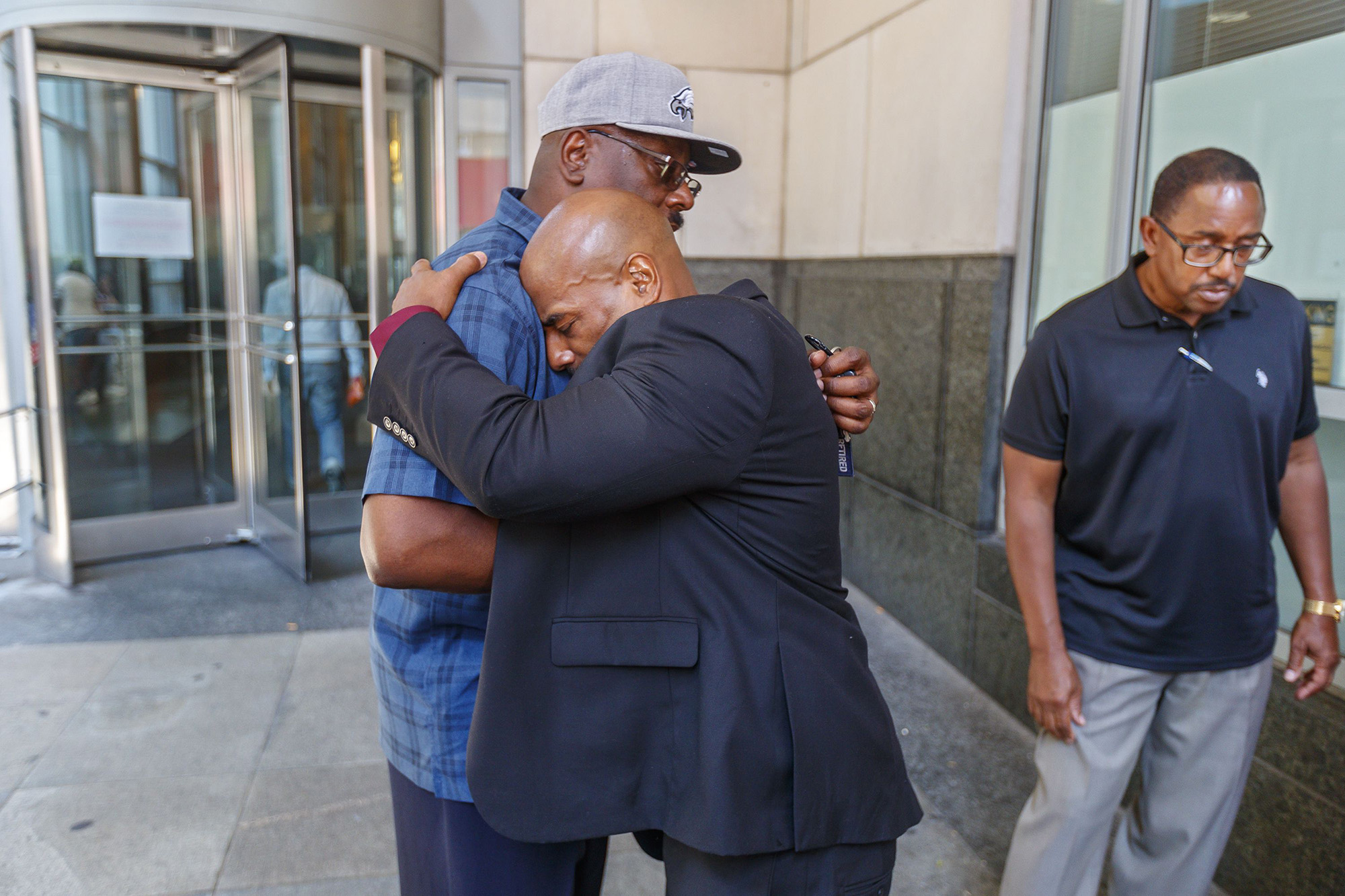 PHOTO: Chester Hollman III, right, buries his head into the chest of his uncle, David Hollman, as the two hugged outside of the Criminal Justice Center.