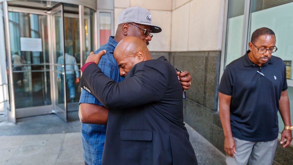 PHOTO: Chester Hollman III, right, buries his head into the chest of his uncle, David Hollman, as the two hugged outside of the Criminal Justice Center.