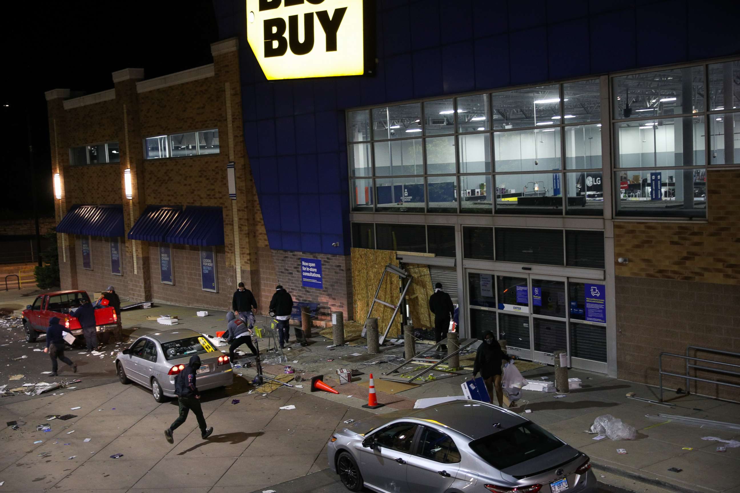 PHOTO: A Best Buy store with broken entrance is seen while people are taking electronics from inside the building in Chicago, Illinois, United States on June 1, 2020.