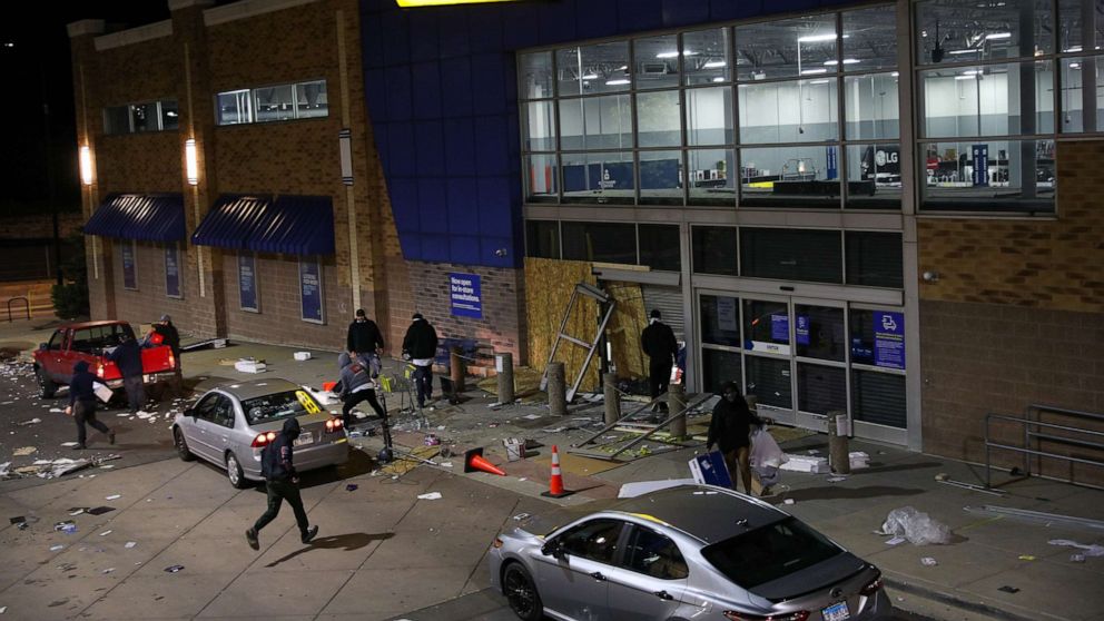 PHOTO: A Best Buy store with broken entrance is seen while people are taking electronics from inside the building in Chicago, Illinois, United States on June 1, 2020.