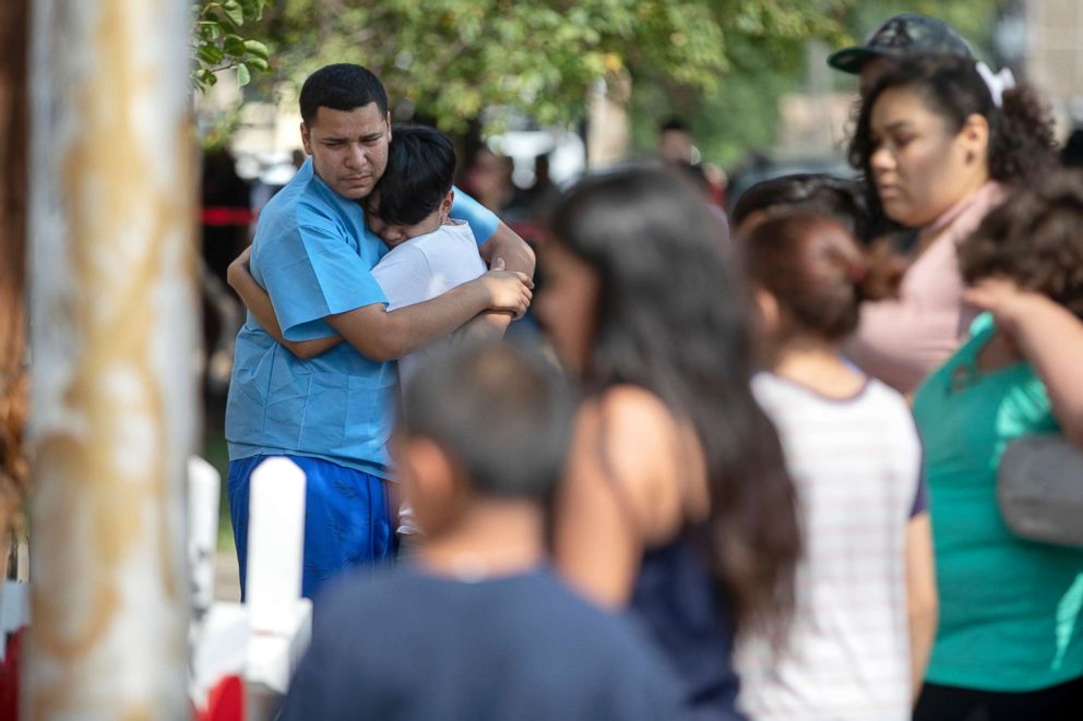 PHOTO: People gather near the scene of a fire that killed at least eight people, including six children, Aug. 26, 2018, in the Little Village neighborhood of Chicago.