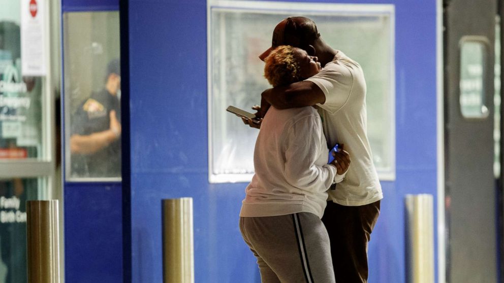 PHOTO: Two people hug one another outside the University of Chicago Medicine's Comer Children's Hospital where a 8-year-old girl was taken after being killed in a shooting in Chicago, Sep. 7, 2020.