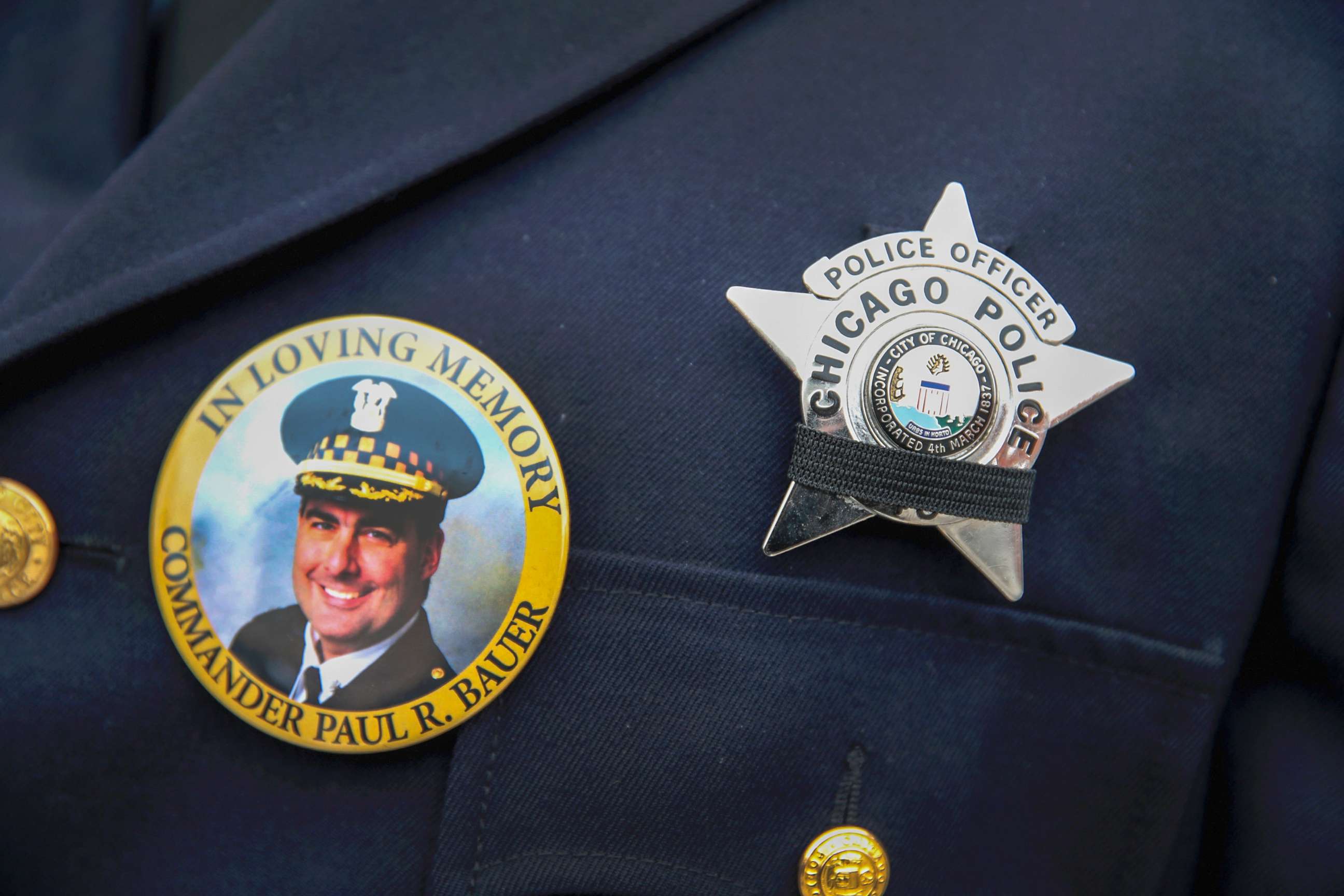 PHOTO: A photograph of Chicago police Commander Paul Bauer is seen on a pin that a Chicago police officer wears as he stands outside of the Nativity of Our Lord church in the Bridgeport neighborhood where Bauer's funeral was held Feb. 17, 2018.
