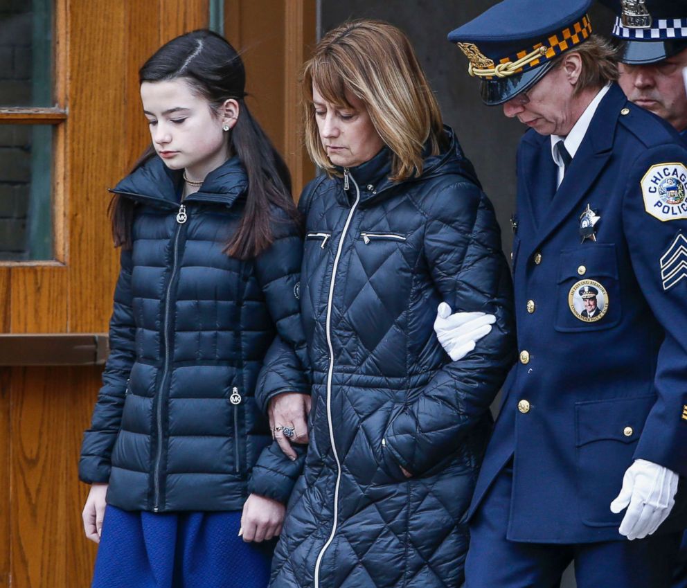 PHOTO: Grace Bauer, left, and her mother Erin, center, are escorted out of the church after attending the funeral service for their father and husband Chicago Police Commander Paul Bauer in Chicago, Feb. 17, 2018. 