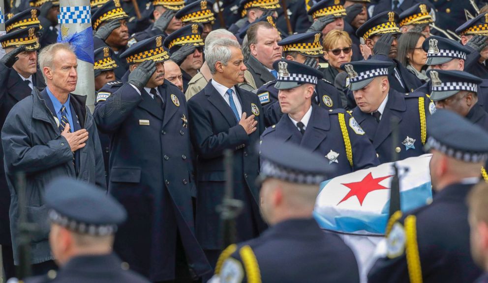 PHOTO: Illinois Gov. Burce Rauner, left, Chicago Police Superintendent Eddie Johnson, second from left, and Mayor Rahm Emanuel salute the casket of Cmdr. Paul Bauer after a funeral mass, Feb. 17, 2018, in Chicago. 