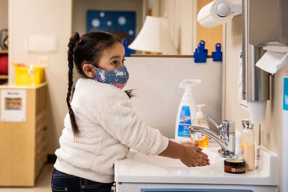 PHOTO: A preschool student washes her hands before breakfast at Dawes Elementary School in Chicago, Jan. 11, 2021.