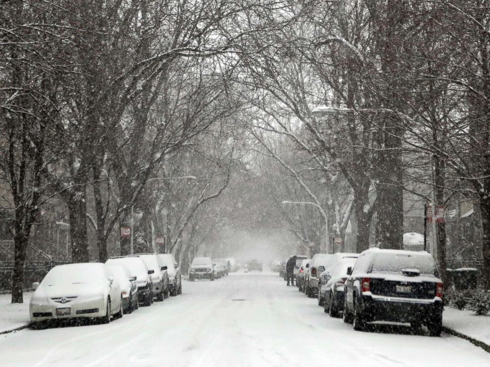 PHOTO: A man digs out his car on the covered streets of the Lakeview neighborhood of Chicago, Dec. 24, 2017. 
