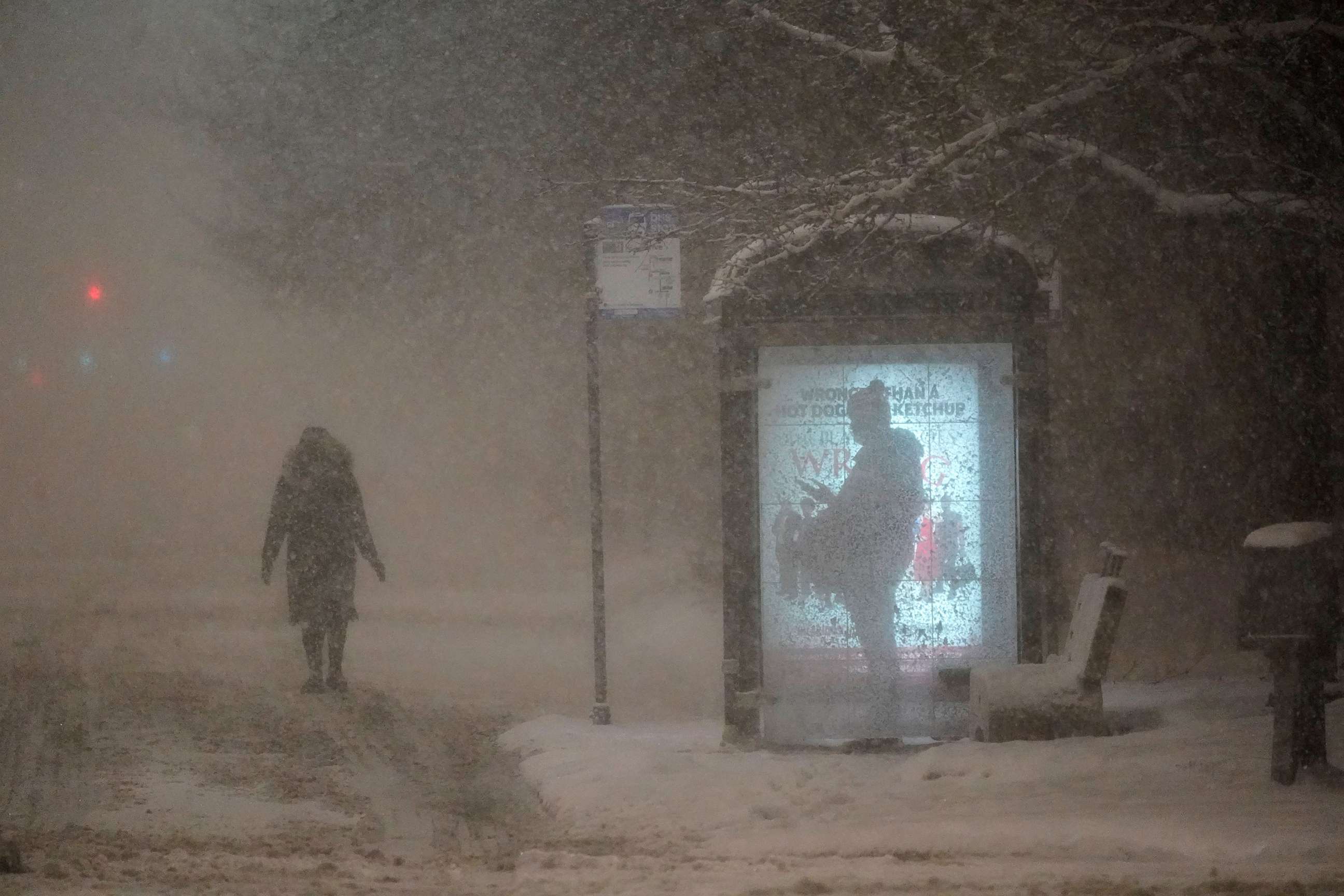 PHOTO: A woman walks to a bus shelter on Dr. Martin Luther King Drive during the pre-dawn hours on Feb. 2, 2022, in Chicago.