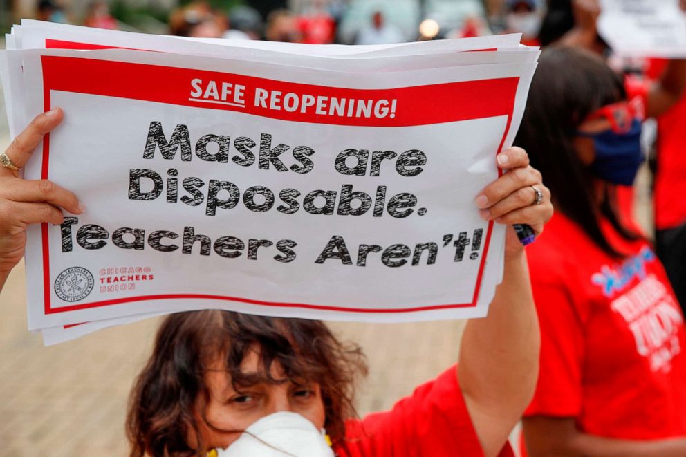 PHOTO: A woman holds a sign during the Occupy City Hall Protest and Car Caravan hosted by the Chicago Teachers Union in Chicago, Illinois, on Aug. 3, 2020.