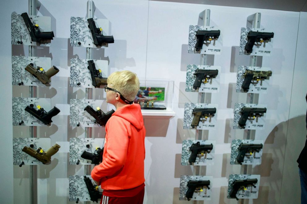 PHOTO: In thie April 28, 2019, file photo, a boy looks at hand guns in the Sig Sauer booth during the third day of the National Rifle Association convention in Indianapolis.