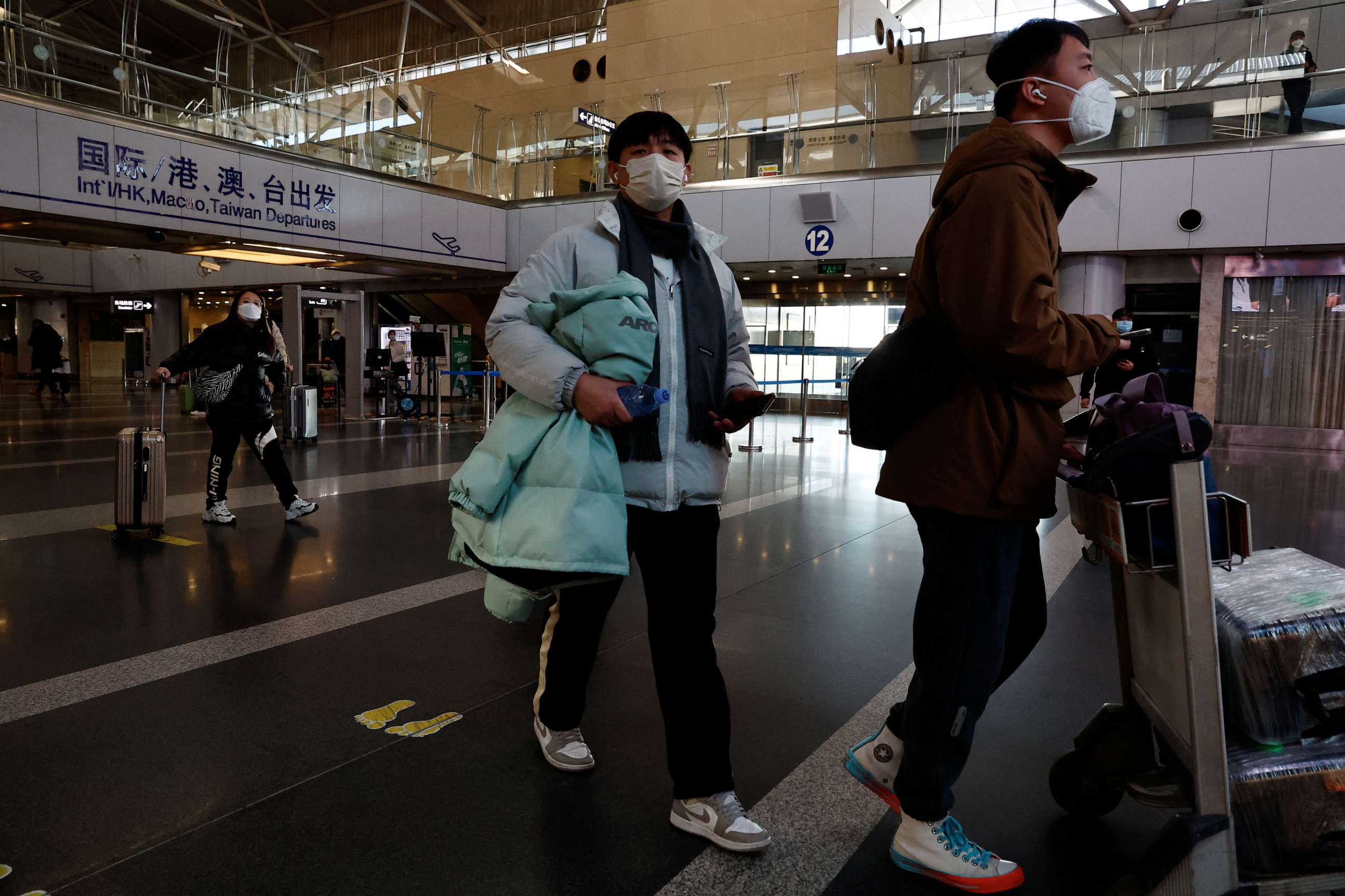 PHOTO: Travelers walk with their luggage through the Beijing Capital International Airport, Dec 27, 2022 in Beijing, China.